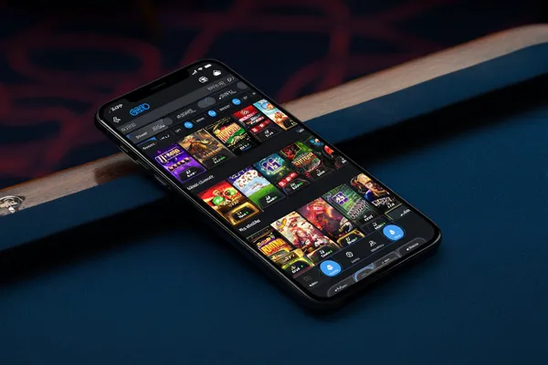 4777BET App — Enjoy seamless gaming on your smartphone A young woman relaxing with her phone while dynamic casino elements float around her, illustrating the smooth mobile experience offered by the 4777BET app.