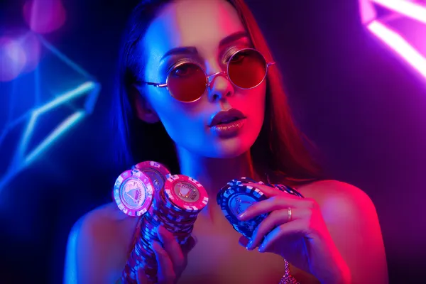 নিয়ন আলোয় আলোকিত পরিবেশে ক্যাসিনো চিপ হাতে এক অভিজাত নারী—যা 4777BET–এর প্রিমিয়াম অনলাইন ক্যাসিনো পরিবেশকে তুলে ধরে।